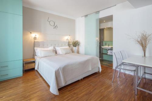 a bedroom with a bed and a table and a desk at Holečkova Apartments in Prague