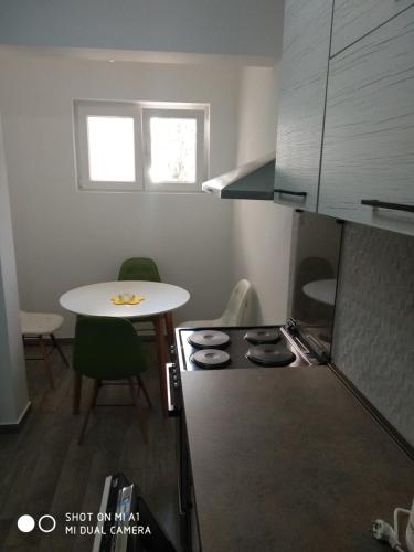 a small kitchen with a table and a stove at Apartment Maska in Budva