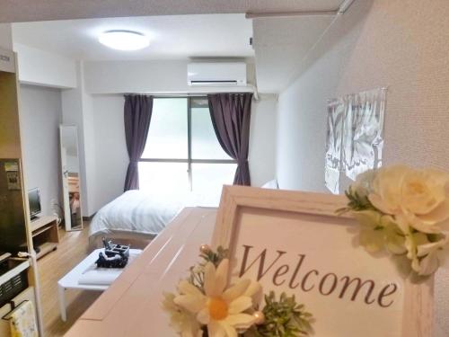 a room with a bed and a table with a welcome sign at Free bike & free WIFI 301 Take it easy in Kyoto
