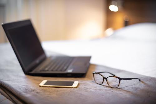 a desk with a laptop and a cell phone and glasses at Hotel Fioreze Centro in Gramado