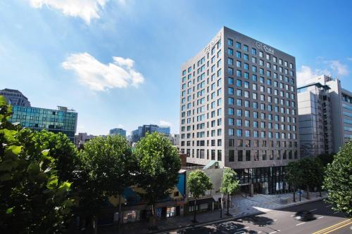 a tall white building on a city street at Orakai Daehakro Hotel, BW Signature Collection in Seoul