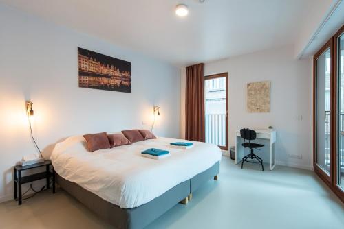 1 dormitorio con 1 cama grande y escritorio en Salt & Pepper Ghent, en Gante