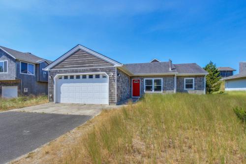 a house with a garage in a field at Sittin' By The Sea in Pacific City