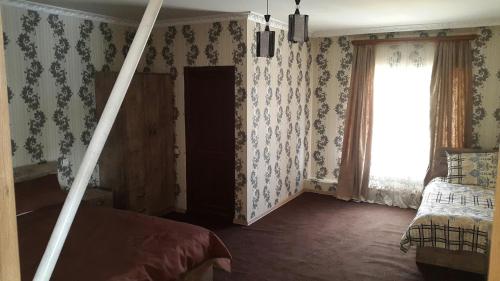 a bedroom with a bed and a window with wallpaper at Lake Tabatskuri in Borjomi