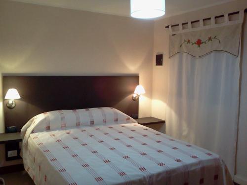1 dormitorio con 1 cama con manta blanca y roja en Casa de Montaña Sacha Huasi en Tafí del Valle