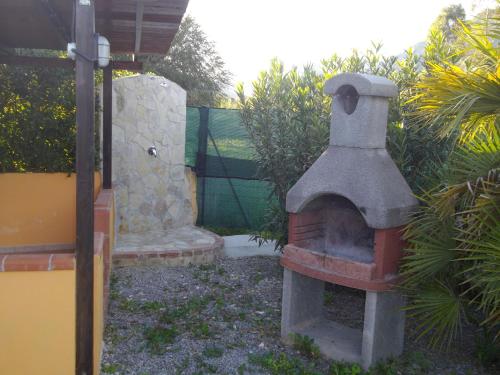 a brick oven in a yard next to a fence at Casa S'Arriali in Iglesias