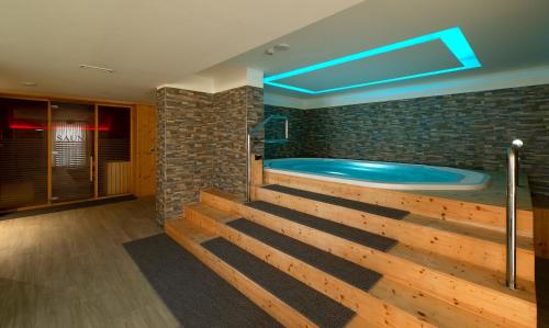 a hot tub in a room with a brick wall at Hotel Terme Paradiso in Abano Terme