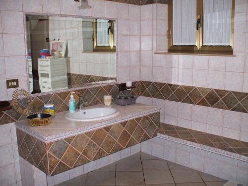 uma casa de banho com um lavatório e um espelho em Casa S'Arriali em Iglesias