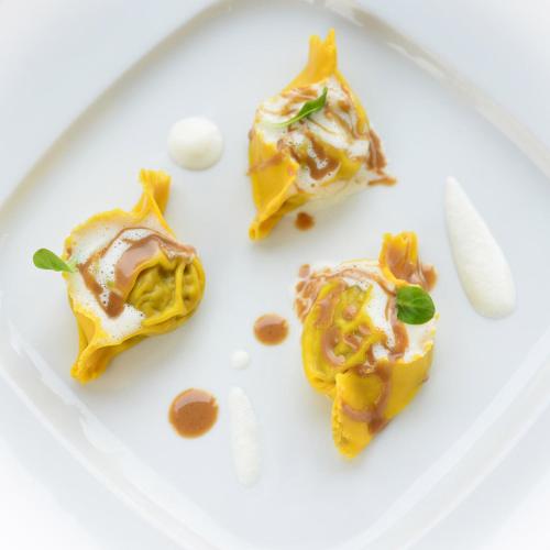 a white plate with three pieces of food on it at Hotel Repubblica 55 in Biella