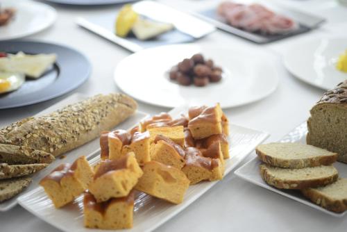 a table topped with plates of bread and pastries at Hotel Repubblica 55 in Biella