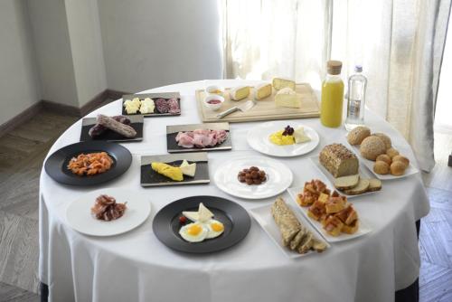 a white table with plates of food on it at Hotel Repubblica 55 in Biella