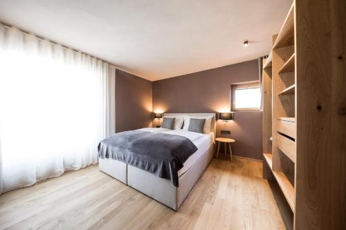 a bedroom with a bed and a large window at Lamondis in Castelrotto