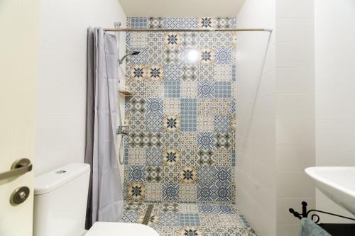 第比利斯Modern Avlabari in Old Town的带淋浴的浴室，铺有蓝白瓷砖