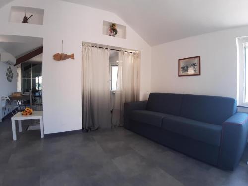 a living room with a blue couch and a table at La Torre by Holiday World in Bogliasco