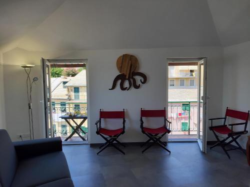 a living room with red chairs and a couch at La Torre by Holiday World in Bogliasco