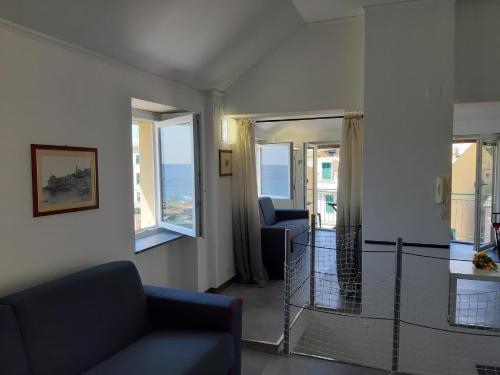 a living room with a couch and two windows at La Torre by Holiday World in Bogliasco