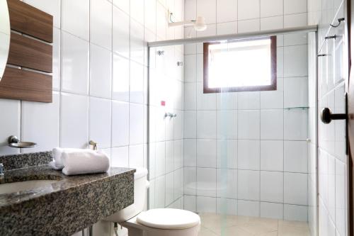 a bathroom with a shower and a toilet and a sink at Pousada Lusitânia in Pedra Azul