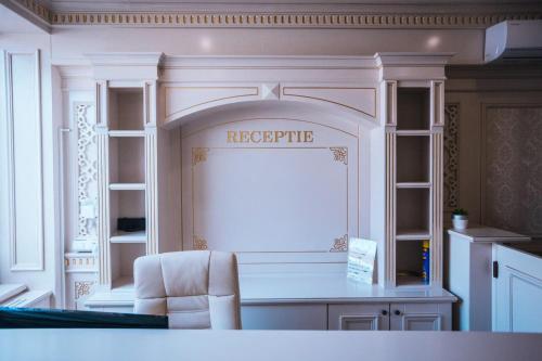 a kitchen with a white counter and a table and a chair at HOTEL GLARIS in Tîrgu Frumos