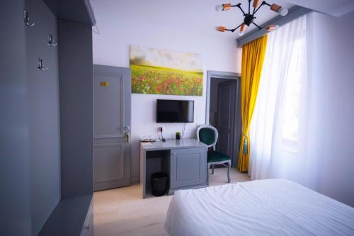 a bedroom with a bed and a desk with a television at HOTEL GLARIS in Tîrgu Frumos
