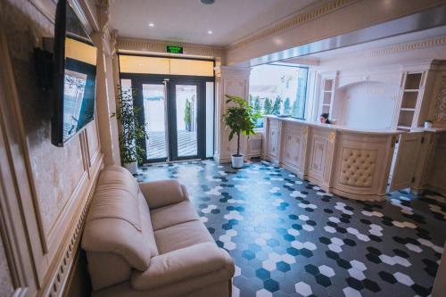 uma sala de estar com um sofá e uma televisão no chão em HOTEL GLARIS em Tîrgu Frumos