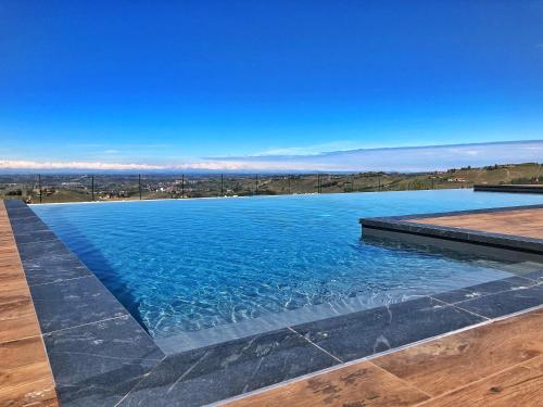 una piscina con acqua blu e cielo limpido di Villa Barbero Alba Langhe a Mango