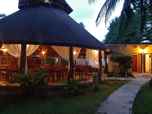 a restaurant with an umbrella and tables and chairs at Samara Beach Hotel in Sámara