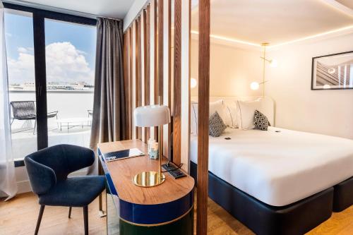 um quarto de hotel com uma cama, uma secretária, uma cama e uma janela em One Shot Fortuny 07 em Madri