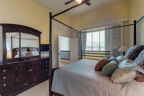 a bedroom with a bed with a dresser and a mirror at Seasons 331 - Penthouse in Sandpoint