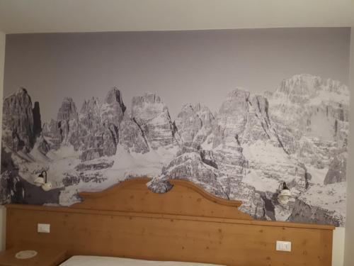 un murale di montagne sulla parete di una camera da letto di Casa Cristina 1 a Molveno