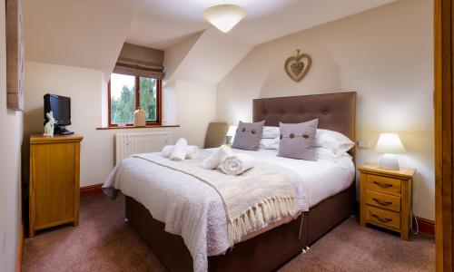 um quarto com uma cama grande e uma televisão em Thomas Fold Cottage em Ambleside