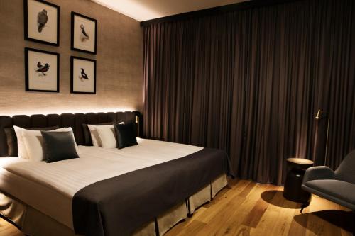 a bedroom with a large bed and a chair at Hotel Reykjavík Grand in Reykjavík