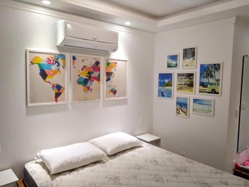 a bedroom with a bed and some pictures on the wall at The Best View in Angra dos Reis