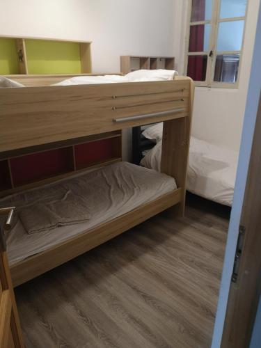 a bunk bed in a room with two beds at La Petite Ecole in Marciac