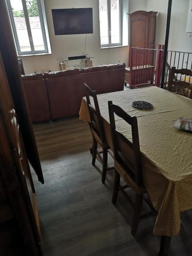 a dining room with a table and chairs and a couch at La Petite Ecole in Marciac
