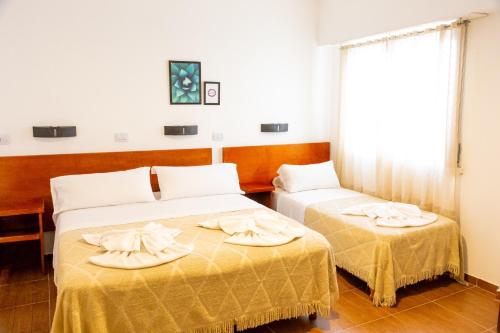 two beds in a hotel room with towels on them at Hotel Ramos Mejía in Mar del Plata