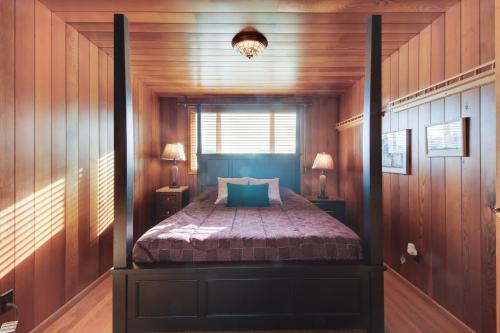 a bedroom with a bed in a room with wooden walls at Lopez Island Agate Beach Waterfront Home in Islandale