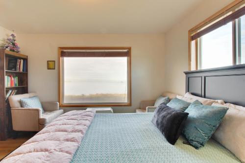 a bedroom with a large bed and a window at Lopez Island Agate Beach Waterfront Home in Islandale