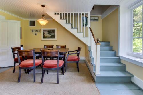uma sala de jantar com mesa, cadeiras e escadas em The Latourette House em Gearhart