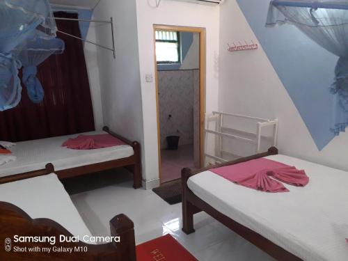 a room with two beds and a doorway at Dilshan Guest in Polonnaruwa