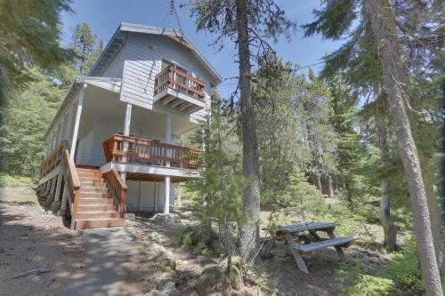a house in the woods with a picnic table and a bench at Bear Creek Cabin in Government Camp