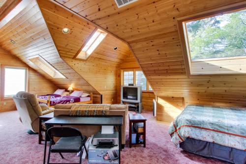 a log cabin bedroom with a bed and a tv at Harrison Loft in Cannon Beach