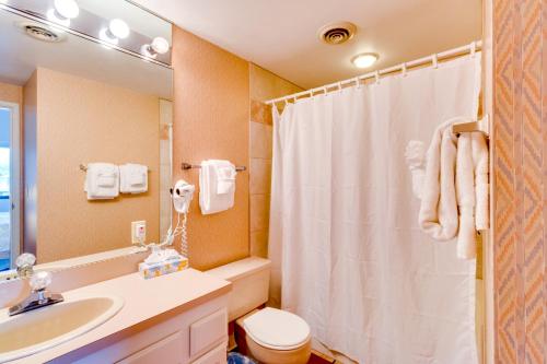 a bathroom with a white shower curtain and a sink at Sand & Sea: The Promenade (100) in Seaside