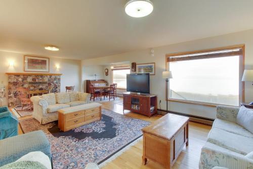 a living room with a couch and a tv at Lopez Island Agate Beach Waterfront Home in Islandale