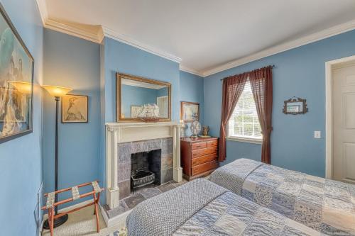 een slaapkamer met blauwe muren en een open haard bij Savannah Lark in Savannah
