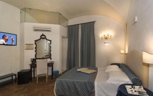 a hotel room with a bed and a mirror at Il Mattino Ha L'Oro In Bocca in Pisa