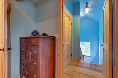 a room with a wooden dresser and a blue wall at The Osprey Perch in Garfield