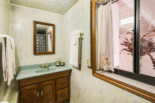 a bathroom with a sink and a mirror and a window at Bella Vista Garden Studio in Hollywood