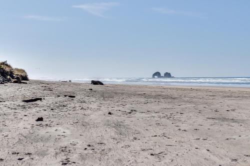 a sandy beach with rocks in the ocean at Auntie's House in Rockaway Beach