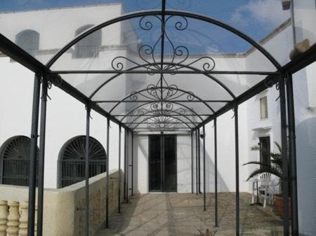 an entrance to a white building with an iron gate at Palazzo Senape De Pace in Gallipoli