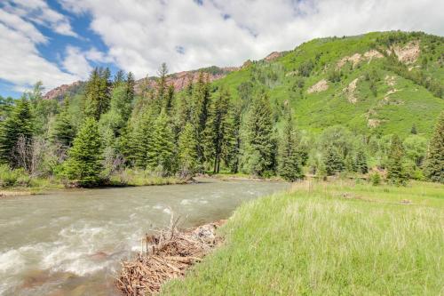 a river with trees and mountains in the background at The Cabins at Filoha Meadows in Redstone